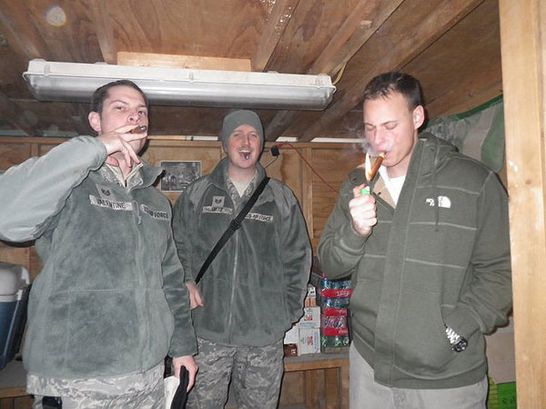 (DEC-12-10) TSgt Daniel Valentine, SSgt Jarad Metz and Christian Sobczak enjoy Cohiba Singlo II cigars at an air field in Afghanistan.