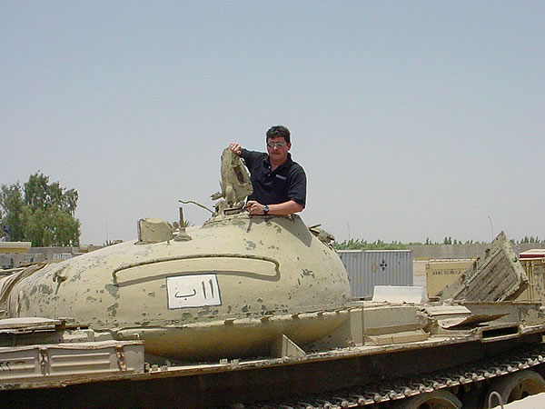 Tracy Coultas, a retired Air Force Senior NCO, now working for Dimensions International as an Army Contractor in the Army Field Support Brigade-Iraq, sits on one of the last Iraqi tanks at Camp Anaconda, Balad, Iraq.