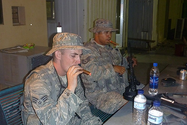 Senior Airman Jacob Thomas and Staff Sergeant (now Technical Sergeant) James Booker enjoying a cigar break while working security in Kuwait. Both are currently enjoying Cohiba cigars from Airman First Class Mykal Anstrom&rsquo;s cigar supply via Cigars International.