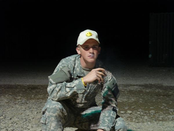Soldier sporting a CI cap and enjoying a cigar.