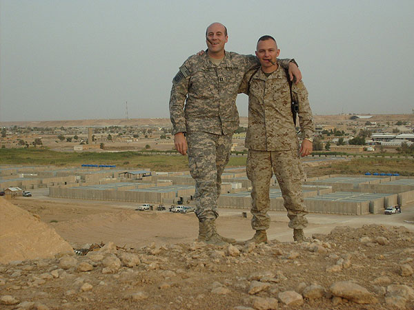 CPT Papka and MAJ Milne smoking CI cigars on the cliffside overlooking an airbase, Iraq. CPT Papka is with the 1st Brigade, 82nd Airborne and MAJ Milne is with the 2 Marine Expeditionary Force.
