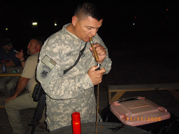SSG Perez lighting a cigar on cigar night.