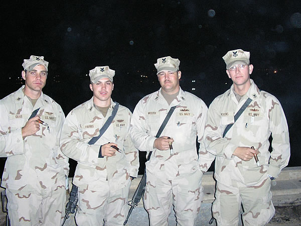 From left to right: AT1 Richie Grau, FT1 Erich Harris, STG1 Joe Wester, and FC1 Drew Pickens from Task Force Hurricane enjoy some cigars from the 3rd story balcony of Al Faw Palace at Camp Victory in Baghdad.