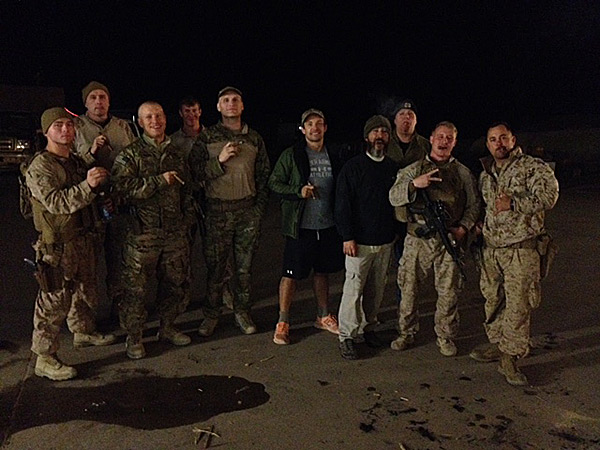 Troops with collation forces and civilian contractors enjoying cigars from Cigars International at a camp in Iraq.