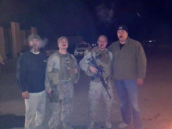 Troops with collation forces and civilian contractors enjoying cigars from Cigars International at a camp in Iraq.