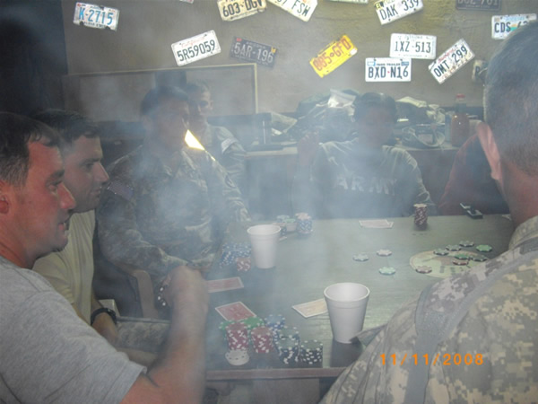 Some soldiers playing poker and enjoying some cigars at the Mudhouse in Iraq